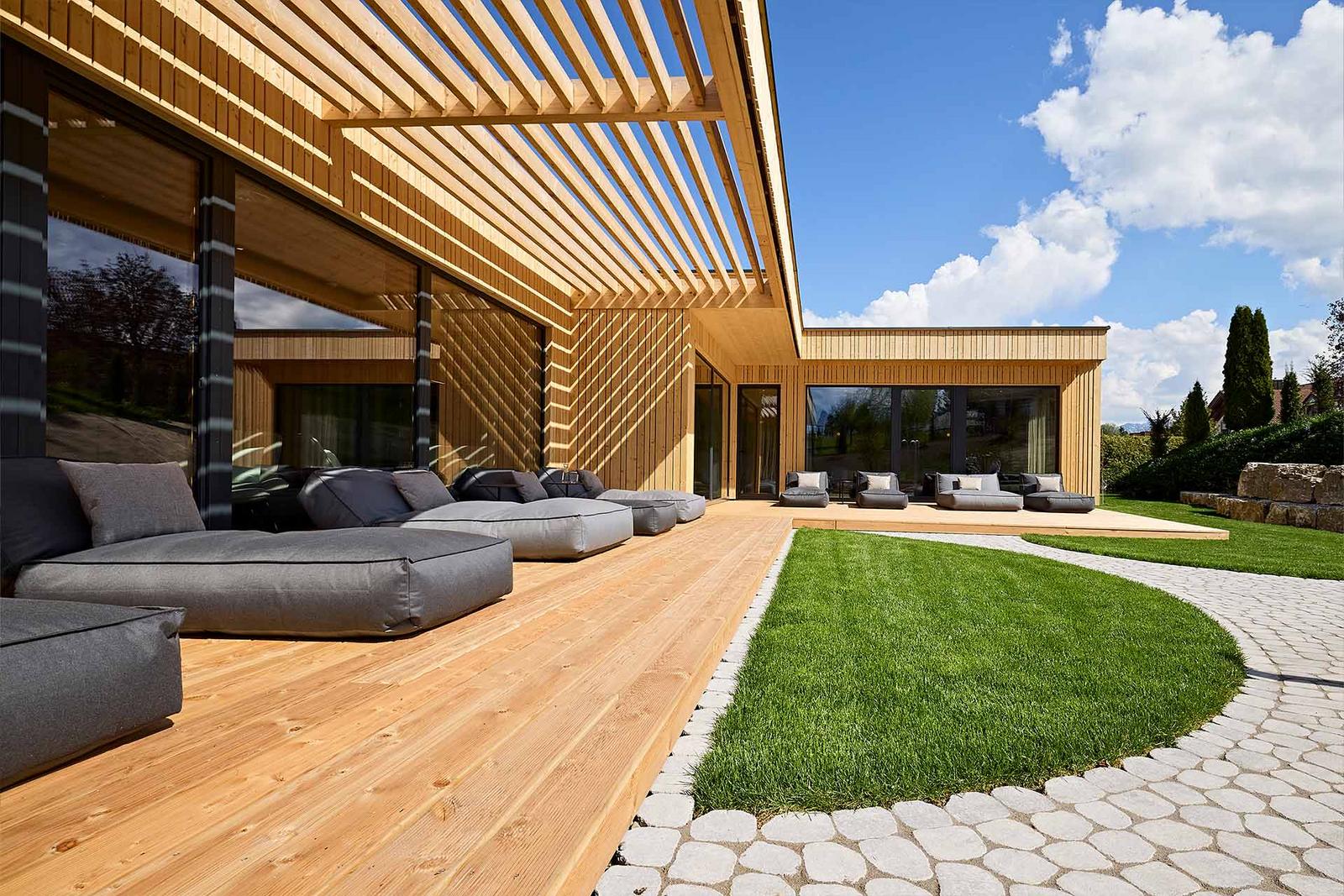 Blick in den Außenbereich des Spas mit Sonnenliegen und Gartenanlage